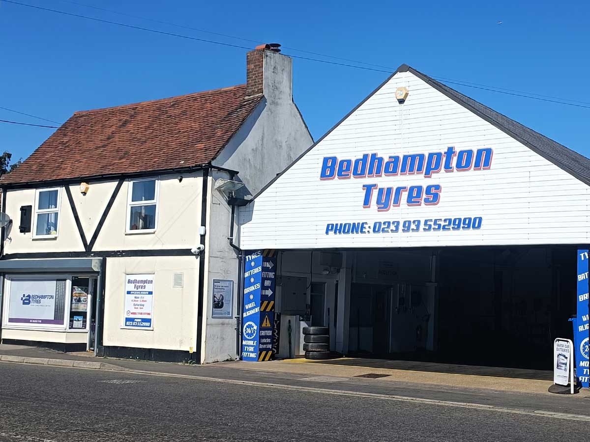 External view of Bedhampton Tyres showing public entrance and workshop with blue signage on the building