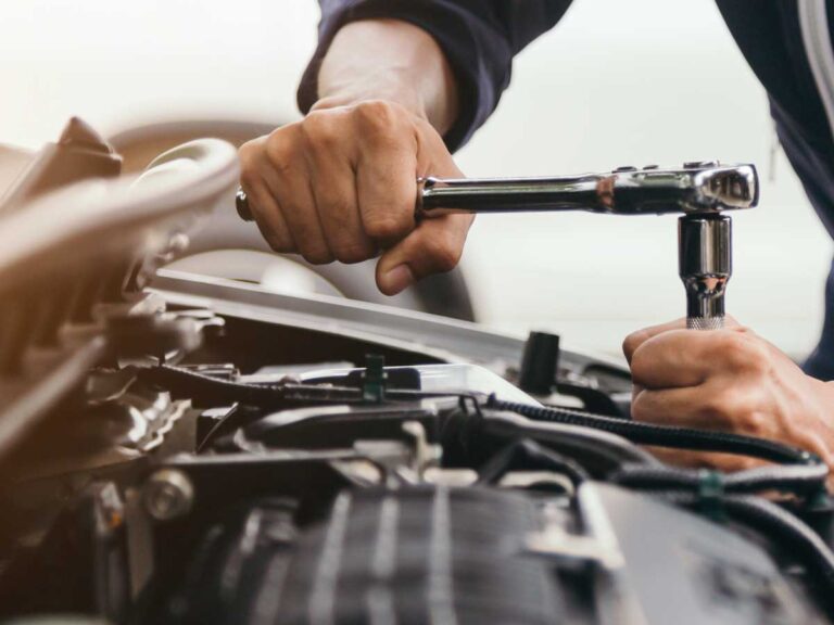 auto technician at bedhampton tyres using a wrench on a the car engine