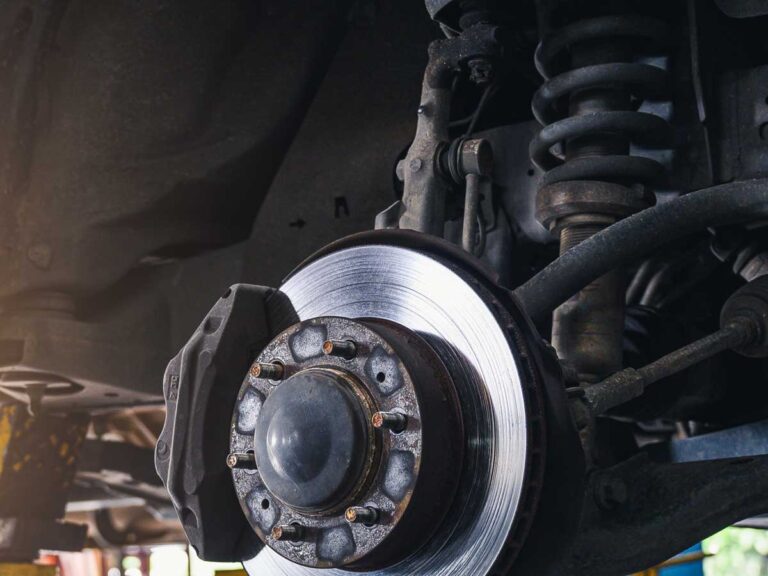 enlarged view of a stripped car suspension system showing brakes. steel coil and mounts