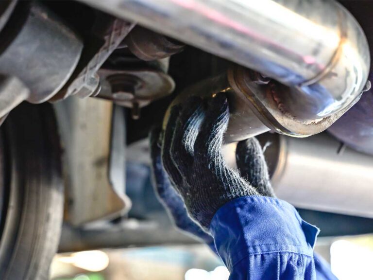 auto technician at bedhampton tyres checking the exhaust system under a car