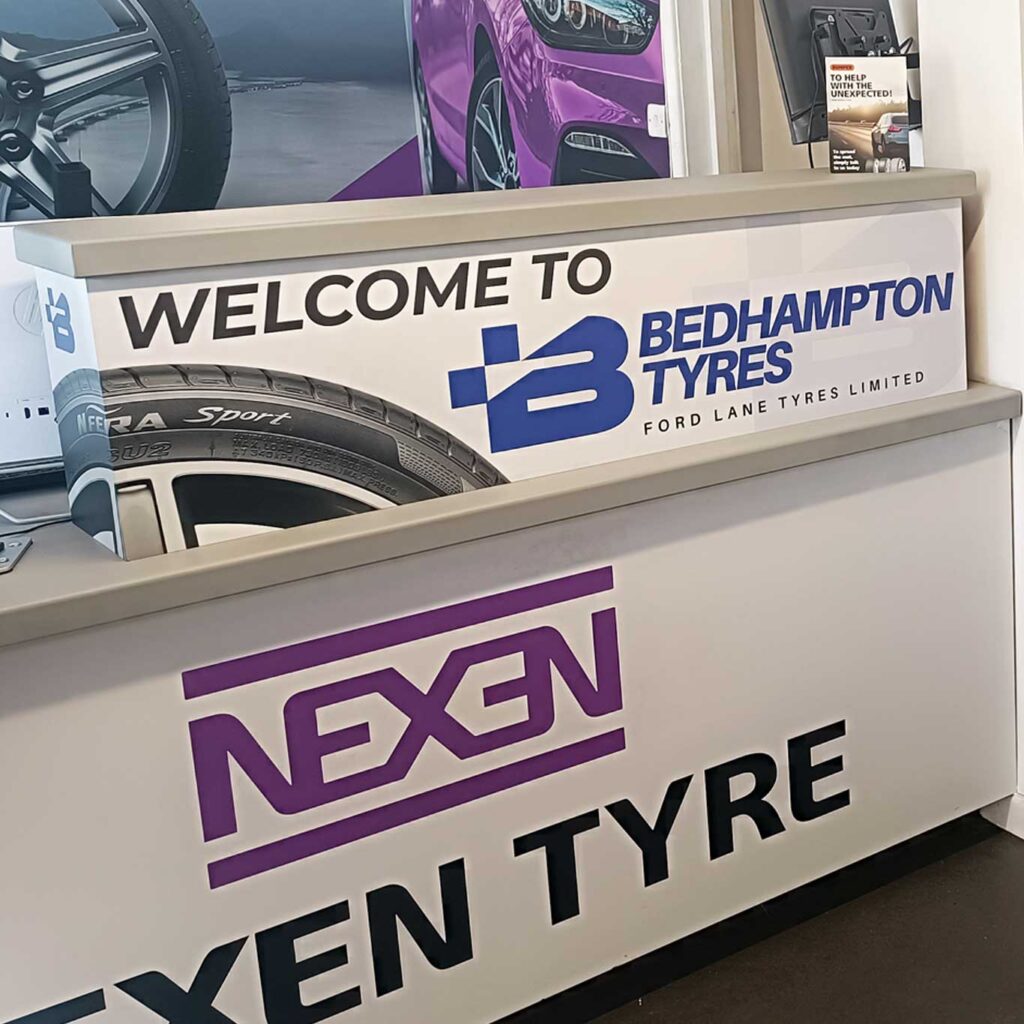 Interior view of the front desk at Bedhampton Tyres with a welcome sign and signage for Nexen Tyres
