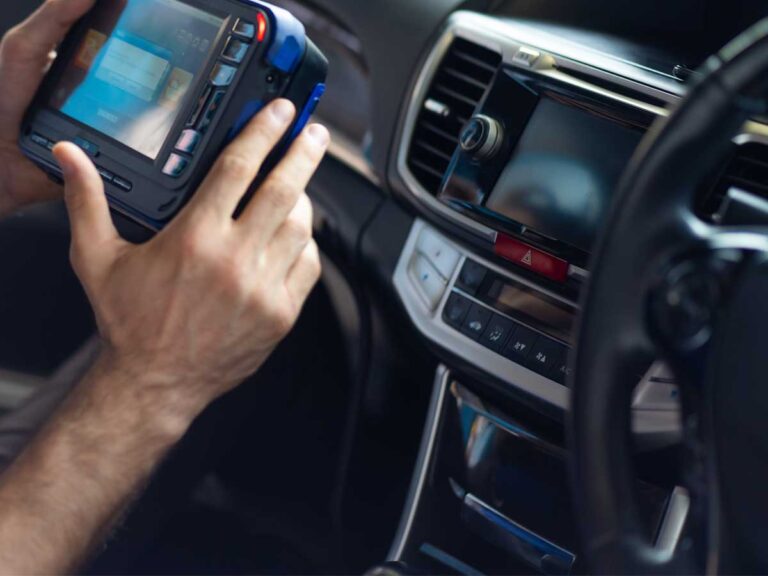 mechanic at bedhampton tyres measuring car diagnostics in the car