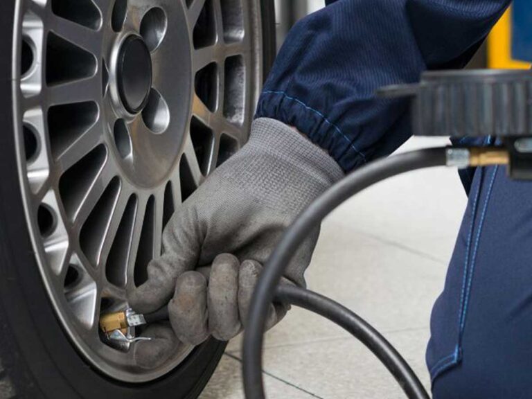 tyre technician at bedhampton tyres using a valve pressure pump on a tyre